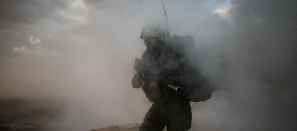 Un soldado israelí de la Brigada de Infantería Nahal atraviesa el humo - Sputnik Mundo