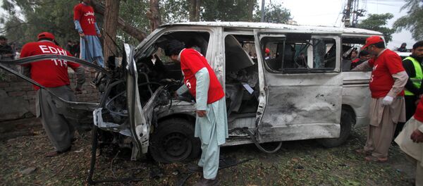 Volunteers search for remains in a vehicle at the scene of a bomb attack in Peshawar, Pakistan - Sputnik Mundo