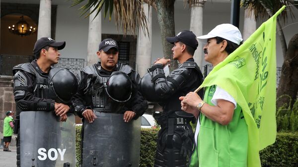 Police guard as supporter of Lenin Moreno, presidential candidate from the ruling PAIS Alliance party, passes by in front of the government palace in Quito, Ecuador, February 16, 2017 - Sputnik Mundo