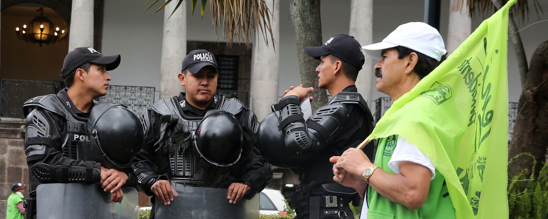 Police guard as supporter of Lenin Moreno, presidential candidate from the ruling PAIS Alliance party, passes by in front of the government palace in Quito, Ecuador, February 16, 2017 Police guard as supporter of Lenin Moreno, presidential candidate from the ruling PAIS Alliance party, passes by in front of the government palace in Quito, Ecuador, February 16, 2017 - Sputnik Mundo, 1920, 26.10.2021