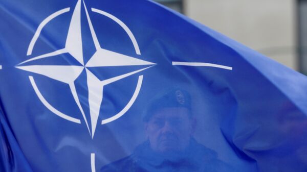 A German soldier holds NATO flag during a ceremony to welcome the German battalion being deployed to Lithuania as part of NATO deterrence measures against Russia in Rukla - Sputnik Mundo