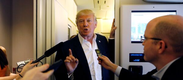 U.S. President Donald Trump speaks with reporters aboard Air Force One - Sputnik Mundo