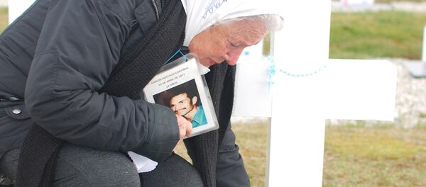 Nora Cortiñas coloca un cartel en una tumba de un soldado desconocido en el Cementerio de Darwin - Sputnik Mundo