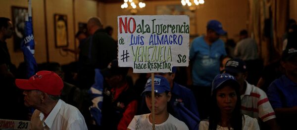 A government supporter holds a placard that reads No to the interference of Luis Almagro. Venezuela is respected during the news conference of Venezuela's Foreign Minister Rodriguez, in Caracas - Sputnik Mundo