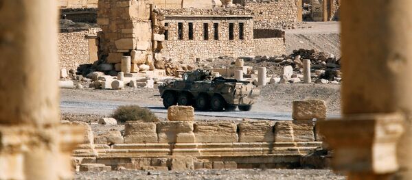 A Russian military vehicle drives near ruins in the historic city of Palmyra, - Sputnik Mundo