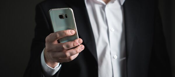 Un hombre con su smartphone - Sputnik Mundo