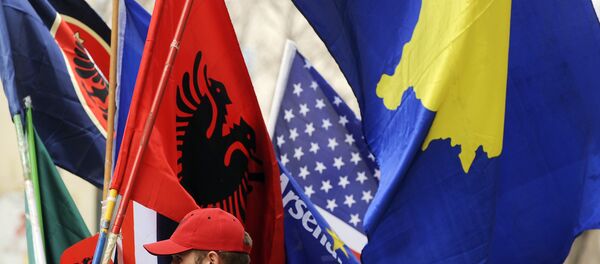 Un hombre vendiendo banderas de Kosovo y Albania - Sputnik Mundo