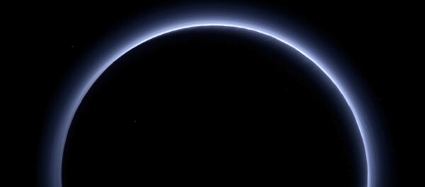 This image released by NASA on Thursday, Oct. 8, 2015 shows a haze layer surrounding Pluto, photographed by the New Horizons spacecraft. This image was generated by software that combines information from blue, red and near-infrared images to replicate the color a human eye would perceive as closely as possible. On Friday, Oct. 28, 2016, NASA said the spacecraft has sent back the last bit of data collected from its July 14, 2015 flyby. It took more than five hours for the image to reach Earth from NASA's New Horizons spacecraft, some 3 billion miles away. - Sputnik Mundo