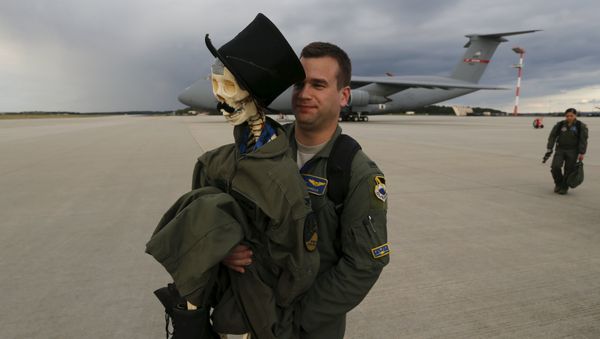 Eric Kordus, a F-22 Raptor fighter jet pilot of the 95th Fighter Squadron from Tyndall, Florida, carries Mr. Bone, the squadron's mascot consisting of a dressed-up plastic skeleton with a stovepipe hat and a moustache, after a refuelling mission of a KC-135 Stratotanker from the NATO airbase of Aemari, Estonia to Spangdahlem, Germany September 4, 2015 Eric Kordus, a F-22 Raptor fighter jet pilot of the 95th Fighter Squadron from Tyndall, Florida, carries Mr. Bone, the squadron's mascot consisting of a dressed-up plastic skeleton with a stovepipe hat and a moustache, after a refuelling mission of a KC-135 Stratotanker from the NATO airbase of Aemari, Estonia to Spangdahlem, Germany September 4, 2015 - Sputnik Mundo