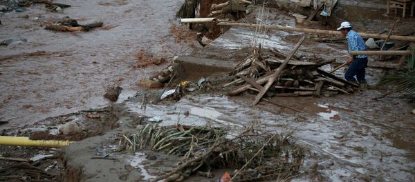 A man searches for his belongings after heavy rains caused several rivers to overflow, pushing sediment and rocks into buildings and roads in Mocoa, Colombia, April 1, 2017. - Sputnik Mundo