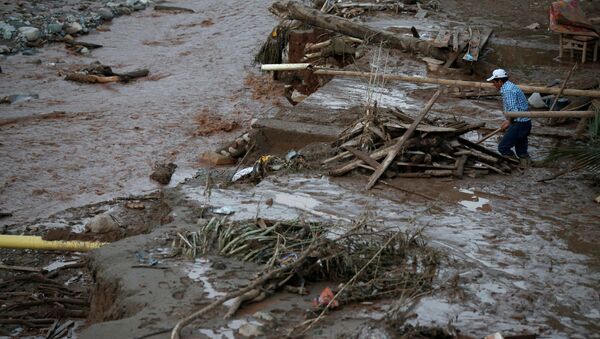 A man searches for his belongings after heavy rains caused several rivers to overflow, pushing sediment and rocks into buildings and roads in Mocoa, Colombia, April 1, 2017. - Sputnik Mundo