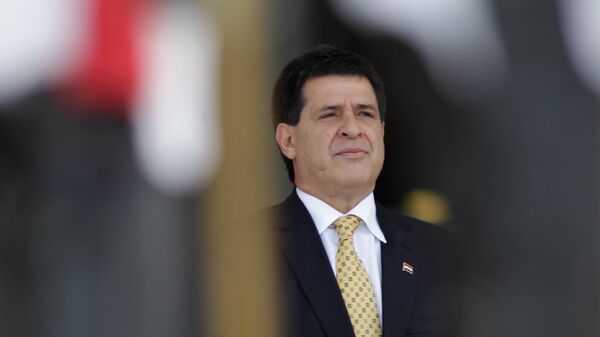 Paraguay’s President Horacio Cartes attends his welcome ceremony at the Planalto presidential palace in Brasilia, Brazil, Monday, Sept. 30, 2013. Cartes' government says it lacks the money to pay salaries for all its public employees and has already laid off thousands of people. Minister Humberto Peralta says they plan to slash thousands more jobs by December - Sputnik Mundo