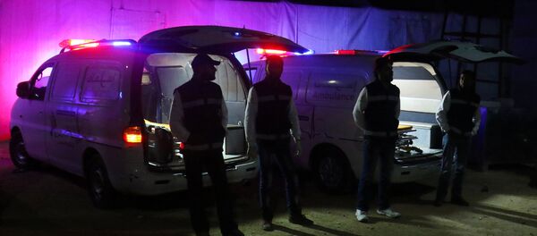 Medics stand outside ambulances as they wait the arrival of people who evacuated the besieged Waer district in the central Syrian city of Homs, in Idlib province, Syria April 2, 2017 - Sputnik Mundo