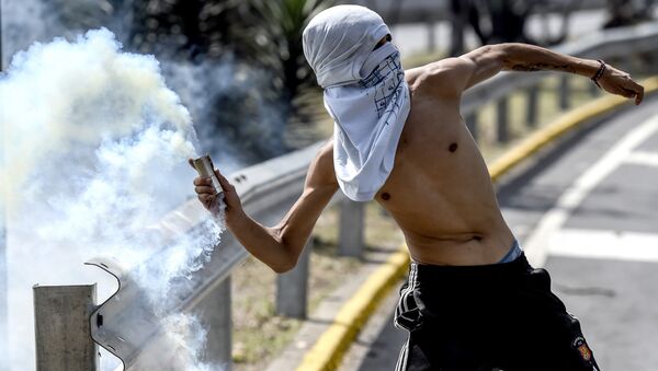 Un hombre lanza gas lacrimógeno, Caracas, Venezuela (archivo) Un hombre lanza gas lacrimógeno, Caracas, Venezuela (archivo) - Sputnik Mundo