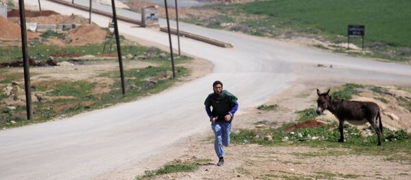 Un médico sirio corriendo durante un ataque al hospital en Idlib - Sputnik Mundo