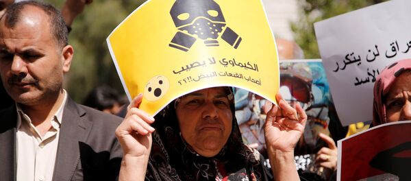 Una manifestante contraria al ataque aéreo de EEUU en Siria porta una pancarta en la que puede leerse: ¿Los productos químicos no afectan a los Cascos Blancos? - Sputnik Mundo