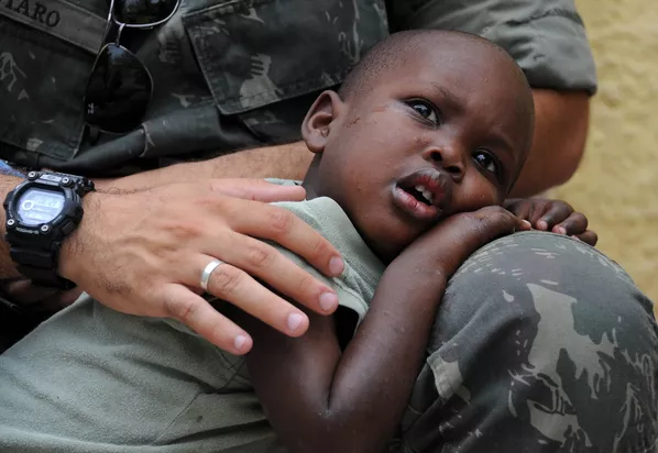 Un soldado de la Misión de las Naciones Unidas para la Estabilización en Haití (Minustah) abraza a un niño que quedó huérfano al morir sus padres en el terremoto de 2010. Un soldado de la Misión de las Naciones Unidas para la Estabilización en Haití (Minustah) abraza a un niño que quedó huérfano al morir sus padres en el terremoto de 2010. - Sputnik Mundo