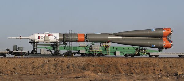 A helicopter flies over Russia's Soyuz-FG booster rocket with the Soyuz MS-04 space ship - Sputnik Mundo