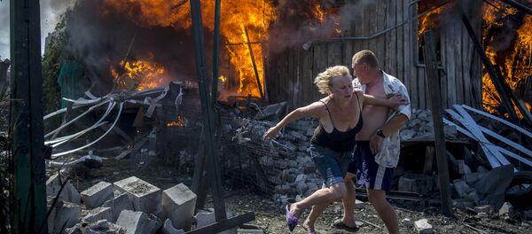 Lugareños de Stanitsa Lugánskaya huyen del incendio producido por un ataque de la Fuerza Aérea de Ucrania, 2 de julio de 2014 - Sputnik Mundo