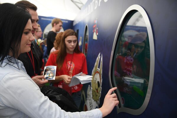 Los visitantes miran la pantalla interactiva del parque  - Sputnik Mundo