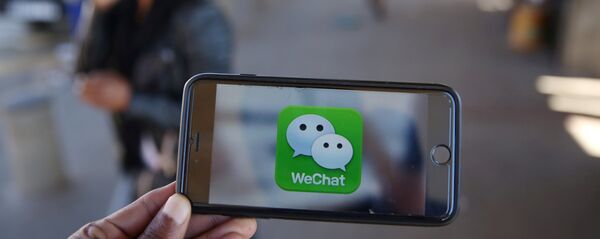 Un logotipo de WeChat se muestra en un teléfono móvil - Sputnik Mundo