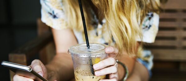 Una mujer sostiene el móvil - Sputnik Mundo