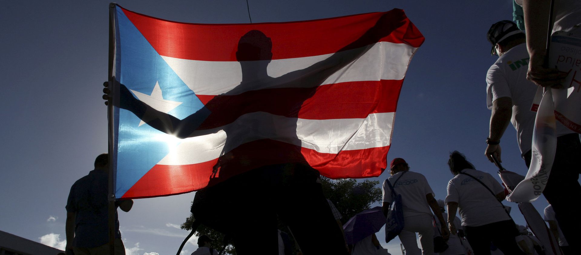 A protester holding a Puerto Rico's flag takes part in a march to improve healthcare benefits in San Juan A protester holding a Puerto Rico's flag takes part in a march to improve healthcare benefits in San Juan - Sputnik Mundo, 1920, 04.11.2020