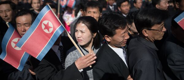 Los ciudadanos de Pyongyang con la bandera de Corea del Norte - Sputnik Mundo