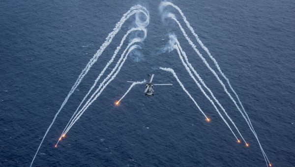 Un helicóptero de la Marina de guerra de EEUU echa bengalas durante un ejercicio de entrenamiento Un helicóptero de la Marina de guerra de EEUU echa bengalas durante un ejercicio de entrenamiento - Sputnik Mundo