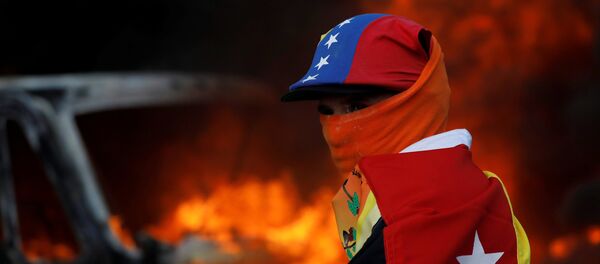 Un participante de las protestas contra el presidente Nicolás Maduro en Caracas, Venezuela - Sputnik Mundo