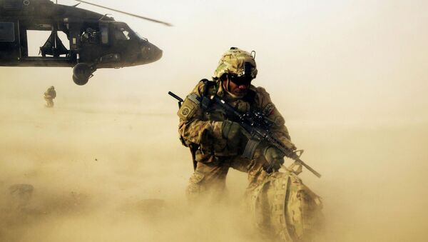 A U.S. soldier from the 3rd Cavalry Regiment shields himself from the rotor wash of a UH-60 Blackhawk helicopter after being dropped off for a mission with the Afghan police near Jalalabad - Sputnik Mundo