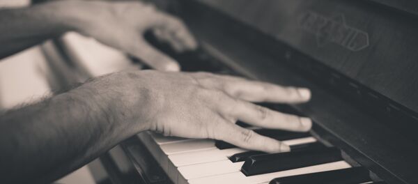Un hombre tocando piano (imagen referencial) - Sputnik Mundo