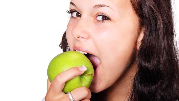 Joven comiendo manzana - Sputnik Mundo