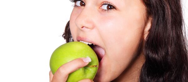 Joven comiendo manzana - Sputnik Mundo