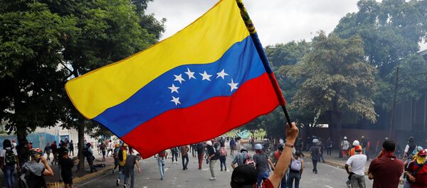 Un manifestante con la bandera de Venezuela - Sputnik Mundo
