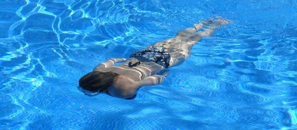 Una mujer en una piscina - Sputnik Mundo