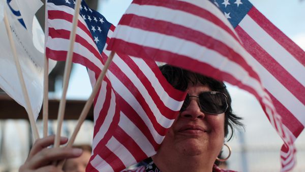 Una mujer con las banderas de EEUU Una mujer con las banderas de EEUU - Sputnik Mundo