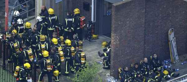 Bomberos durante un descanso en Londres tras luchar contra el incendio de las viviendas Grenfell Tower - Sputnik Mundo