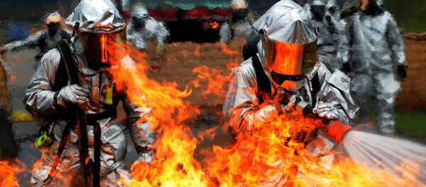 Unos bomberos intentan apagar el fuego (imagen referencial) - Sputnik Mundo