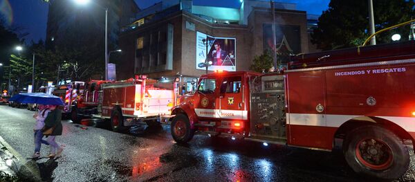 Colombian firefighters stand outside a shopping center following an explosion inside the building - Sputnik Mundo