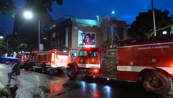 Colombian firefighters stand outside a shopping center following an explosion inside the building - Sputnik Mundo