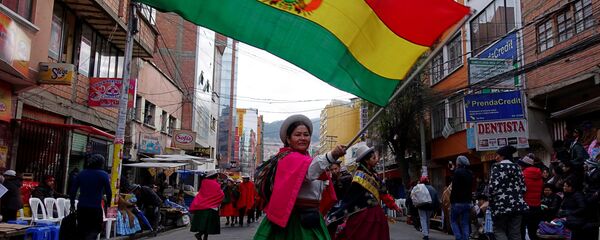 Una mujer indígena con la bandera de Bolivia Una mujer indígena con la bandera de Bolivia - Sputnik Mundo