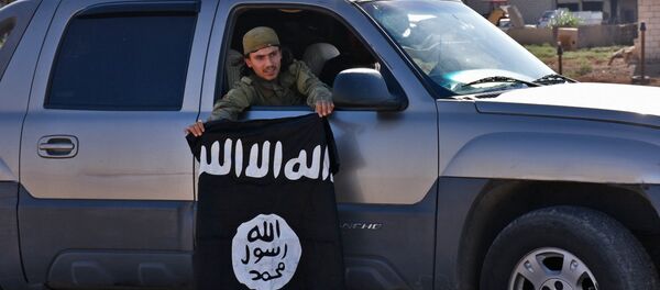 Un combatiente pro-gubernamental sirio demuestra la bandera de Daesh sacada de una aldea liberada Un combatiente pro-gubernamental sirio demuestra la bandera de Daesh sacada de una aldea liberada - Sputnik Mundo