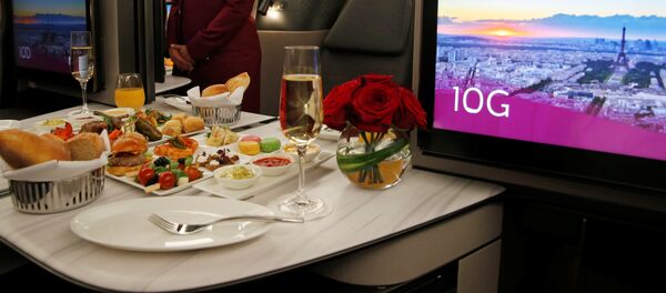 Azafata de Qatar Airways presenta asientos de la primera clase de un Boeing 777 - Sputnik Mundo
