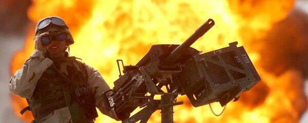 A US soldier looks through a pair of binoculars as a fire in the Rumeila oil field burns in the background in southern of Iraq, Sunday, March. 30, 2003 - Sputnik Mundo