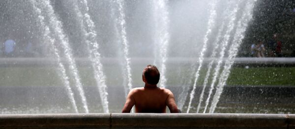 Un hombre en una fuente salvándose del calor enorme, Bruselas, Bélgica - Sputnik Mundo