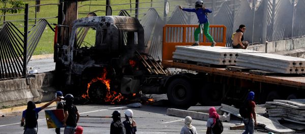 Manifestantes de oposición tumban rejas de base aérea militar venezolana en Caracas - Sputnik Mundo