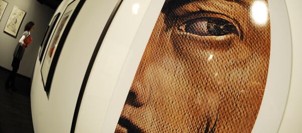 A woman walks past works by Spanish artist Salvador Dali as in the foreground can be seen a photocollage titled Macrophotographic Self-Portrait with the Appearance of Gala as a Spanish Nun at Berlin's new Dali Museum on February 3, 2009 - Sputnik Mundo