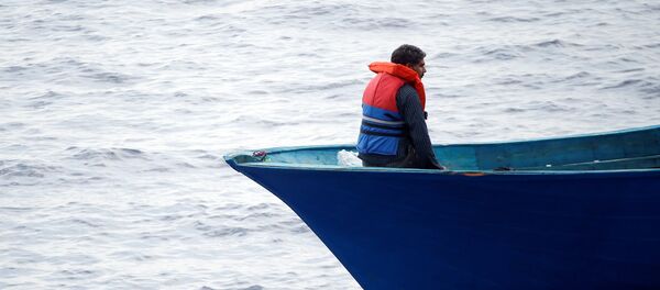 Un migrante en el barco en el Mediterráneo - Sputnik Mundo