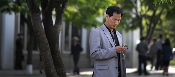 Un hombre con un teléfono celular - Sputnik Mundo